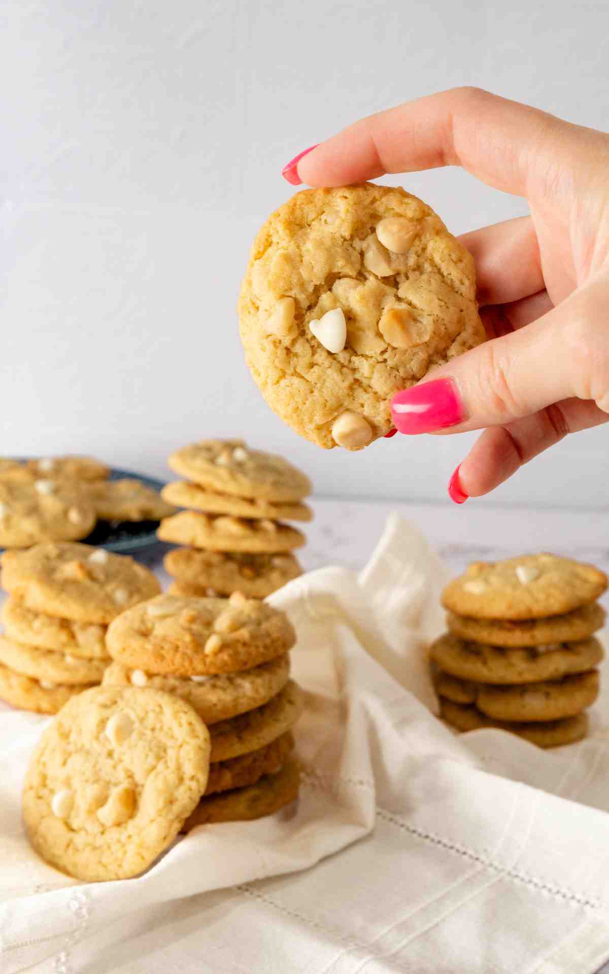 A hold holding a lemon macadamia nut cookie.