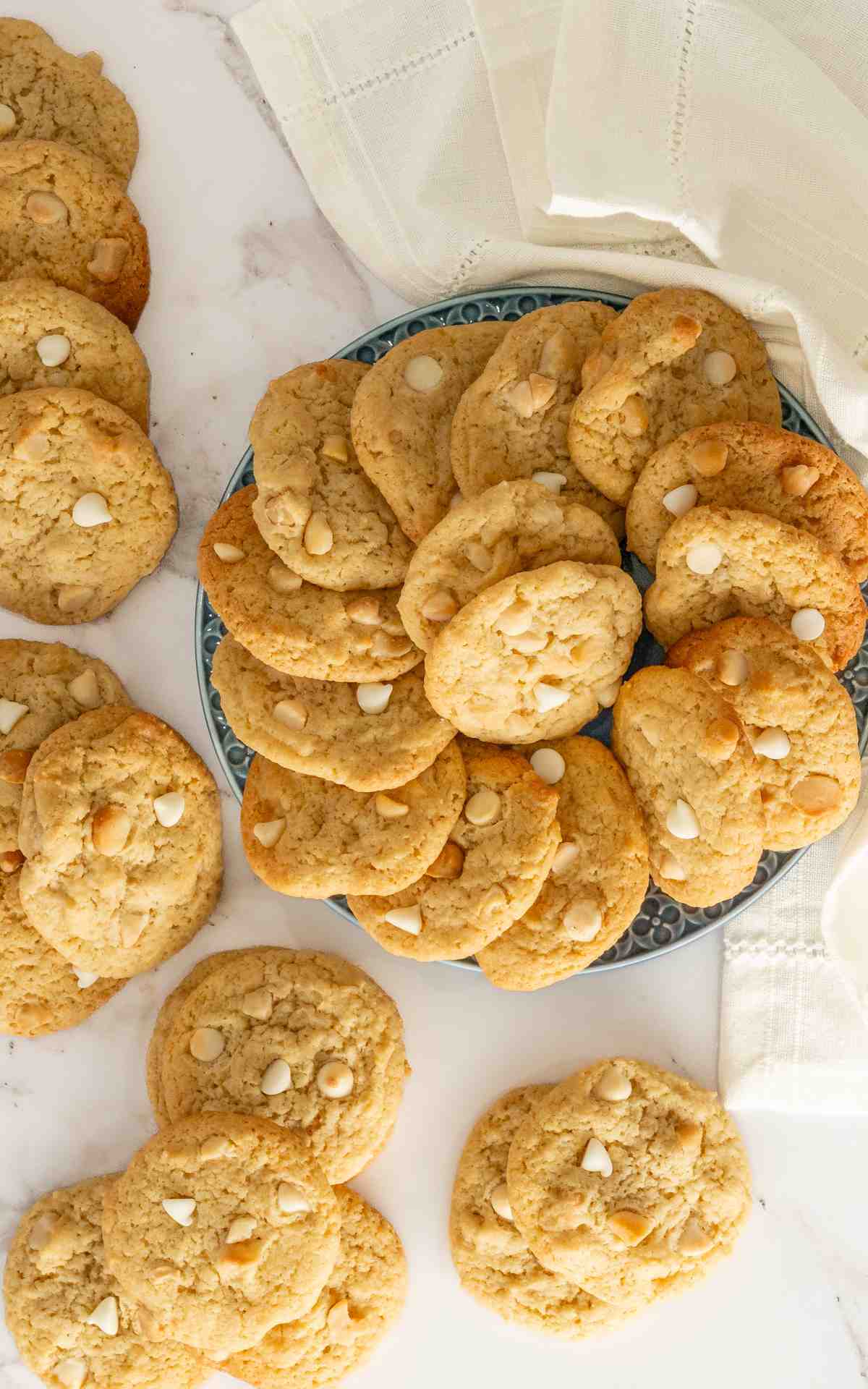 A platter of lemon macadamia nut cookies with cookies on the counter.