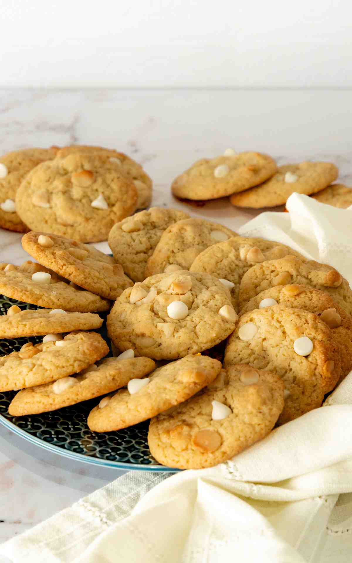 Side view of a green platter of lemo cookies with nuts and white chocolate.