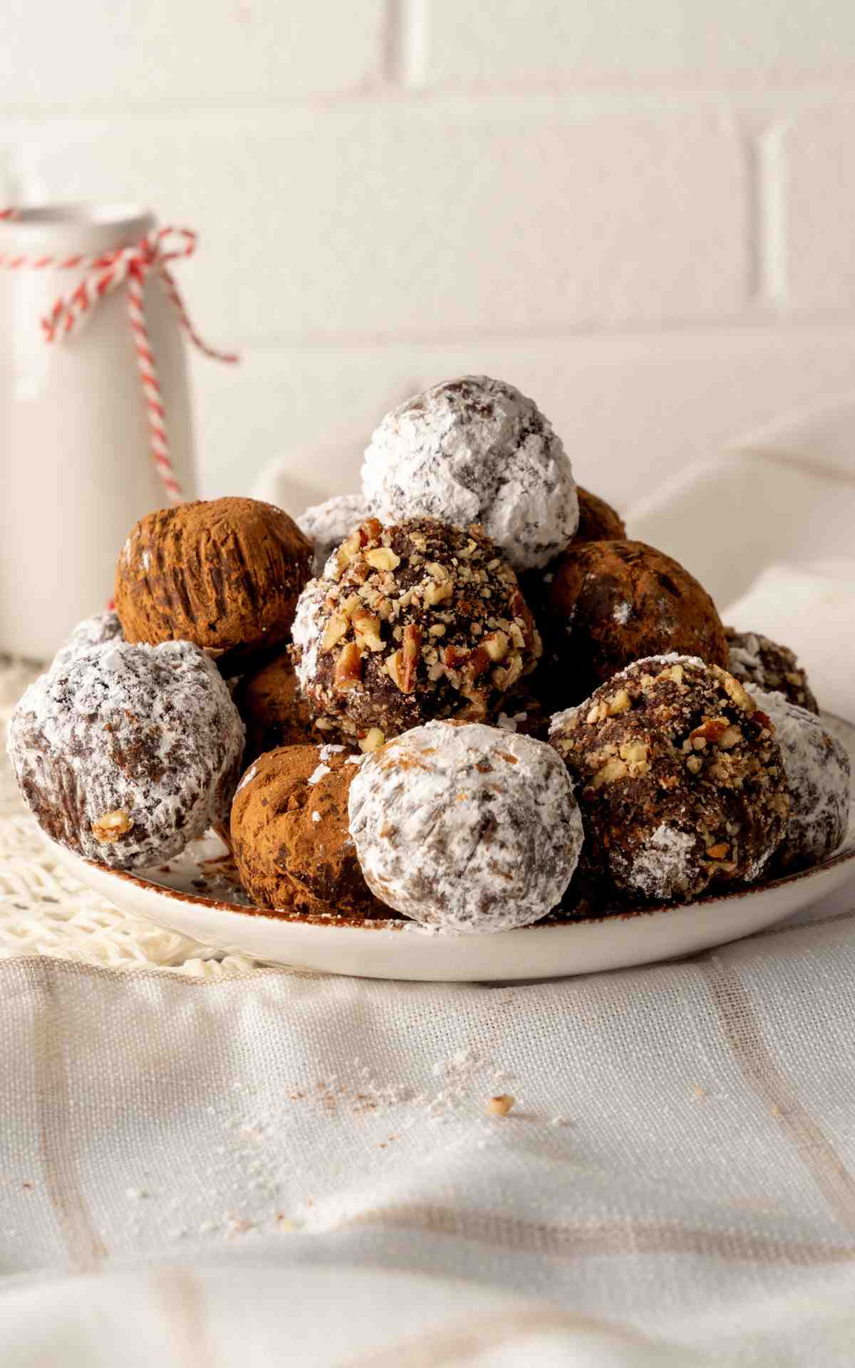 A plate of a traditional rum balls rolled in different toppings on a plate.