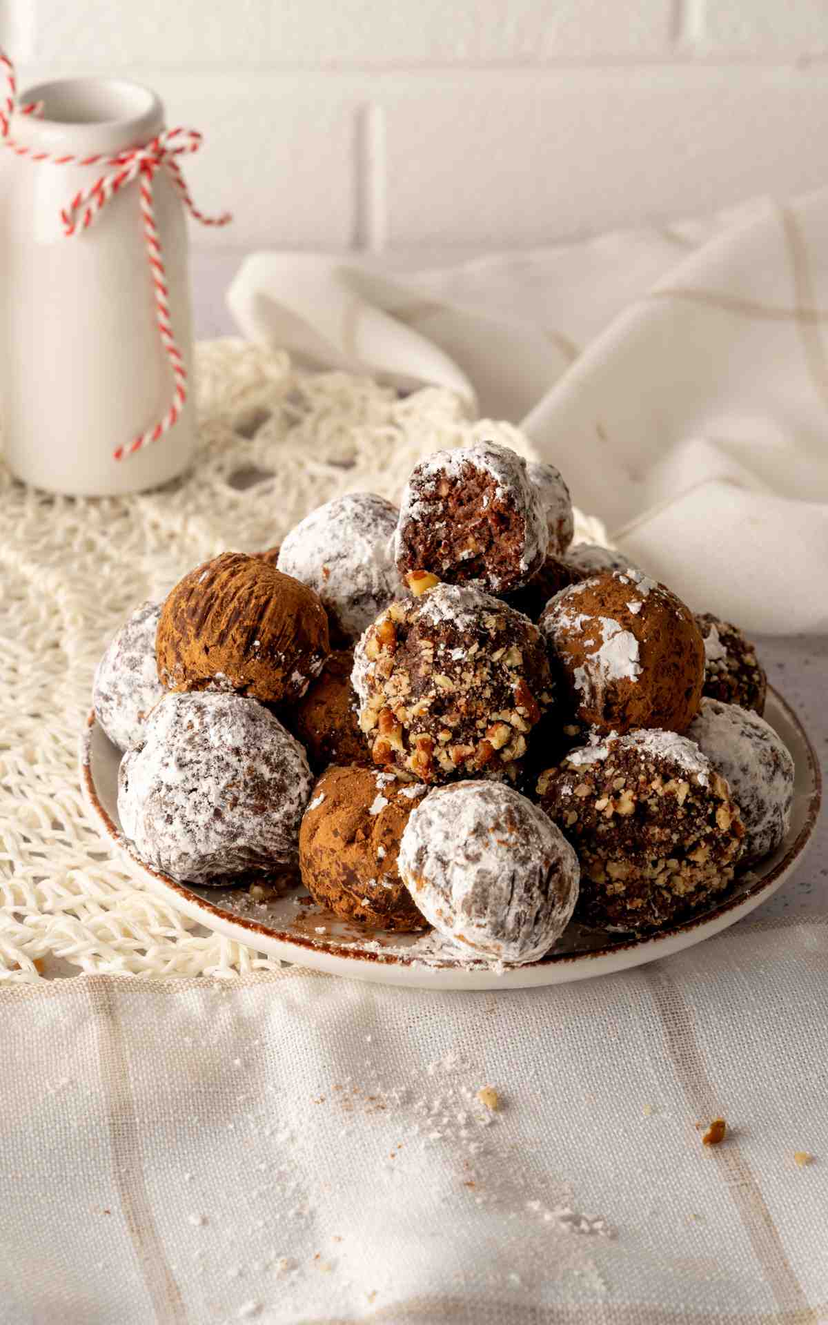 A stack of traditional rum balls on a Christmas plate.
