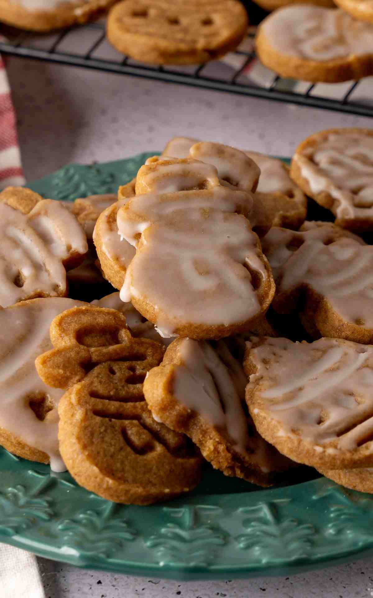 A plate of cutout molasses cookies on a green plate.