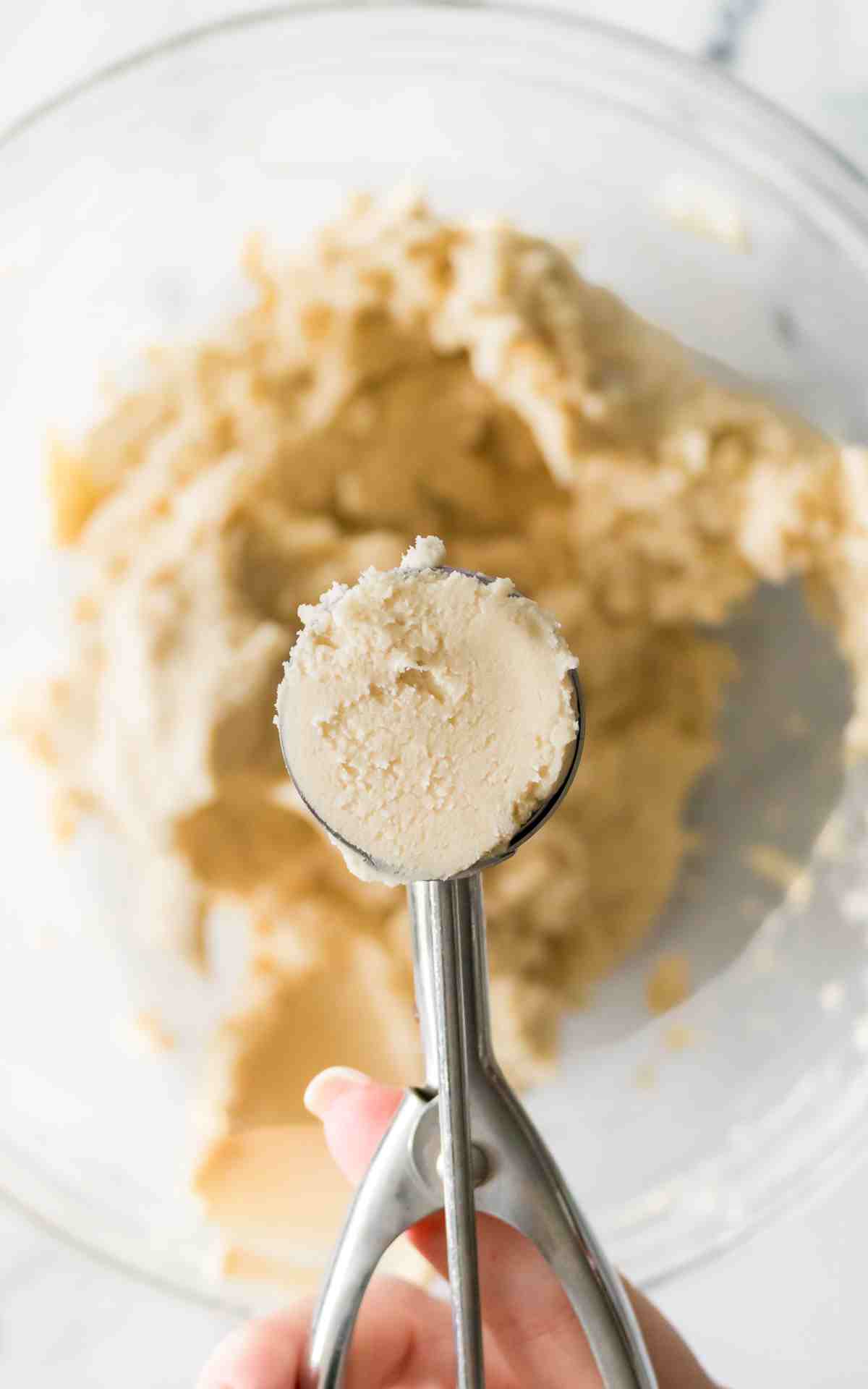 A cookie scoop filled with whipped shortbread cookie dough.