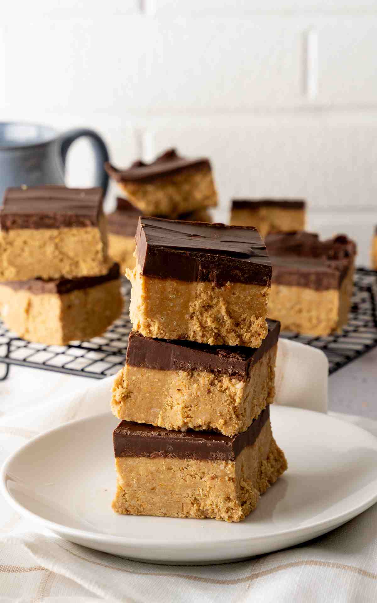 A plate of peanut butter bars topped with a thick layer of chocolate.