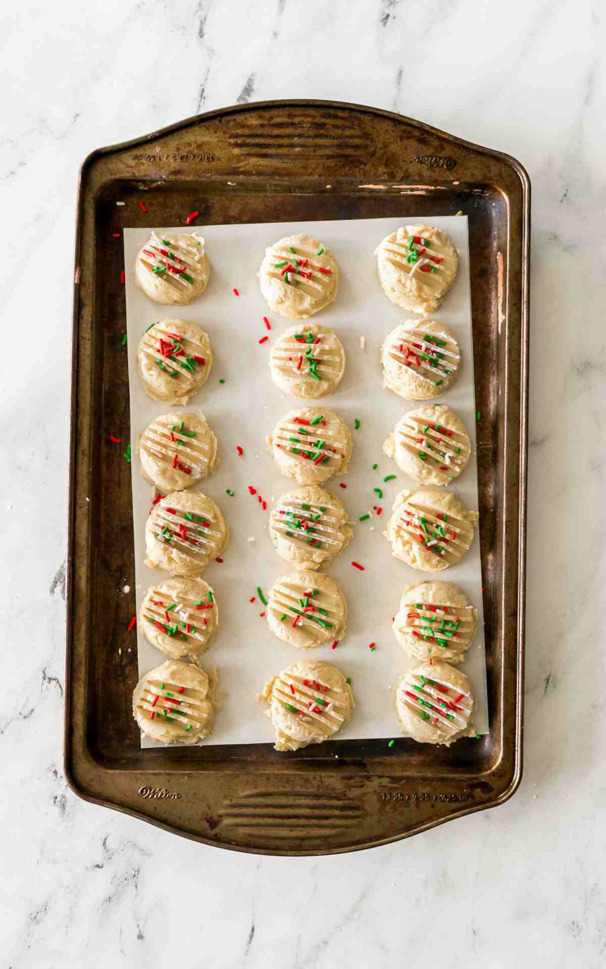 Drop Shortbread cookies on parchment paper on a cookie sheet.