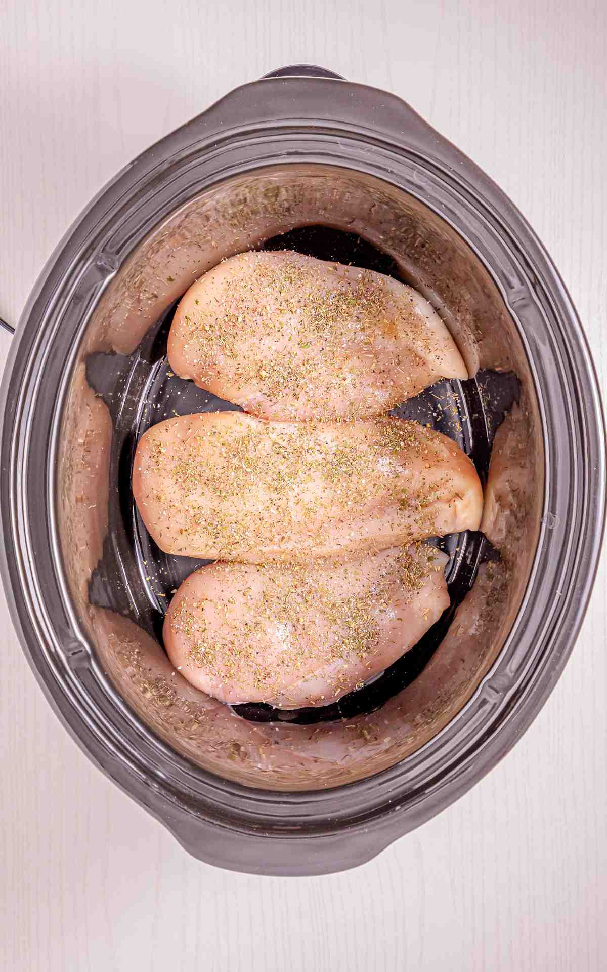 Seasoned chicken in a Crockpot.