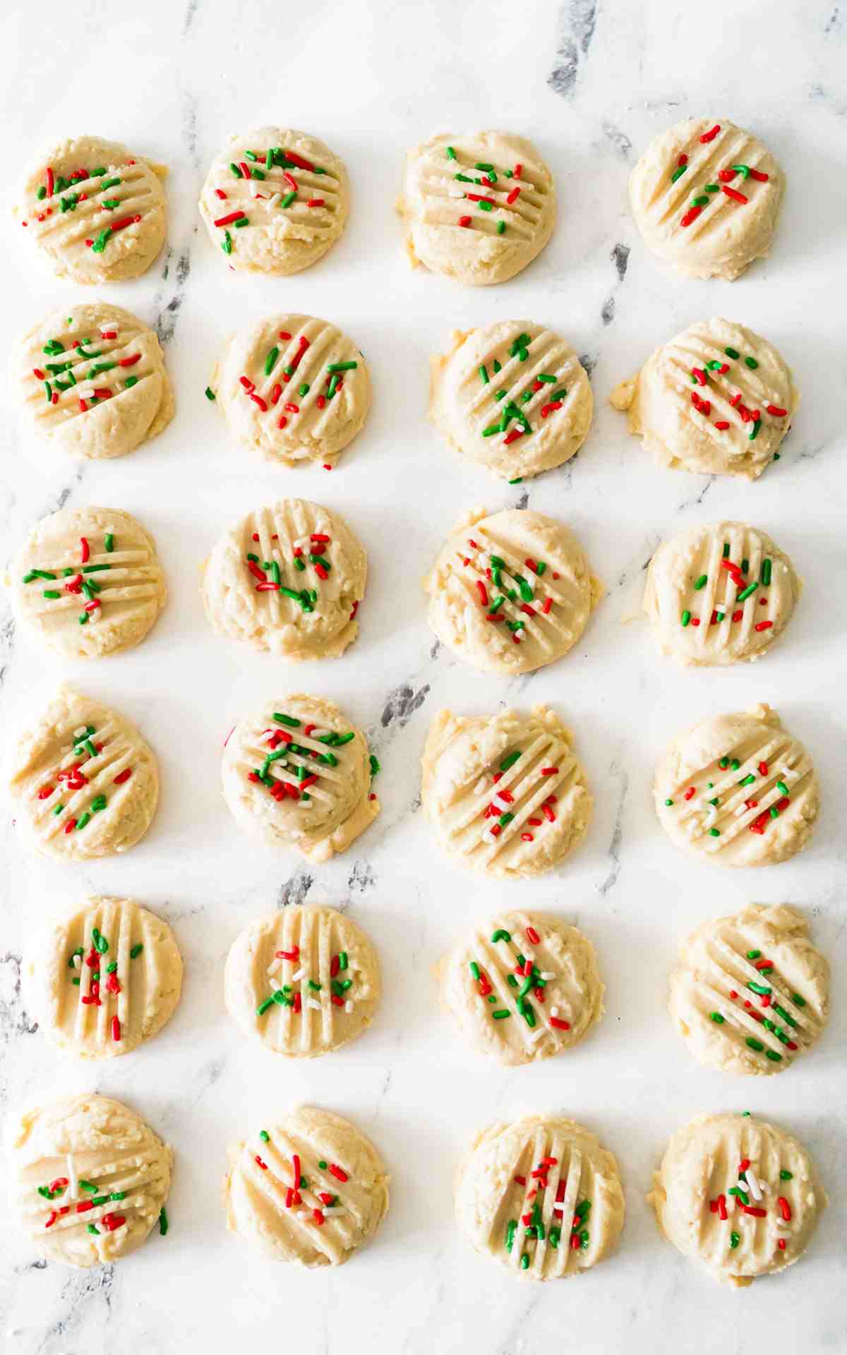 Whipped shortbread cookies with lines cut into it with sprinkles.