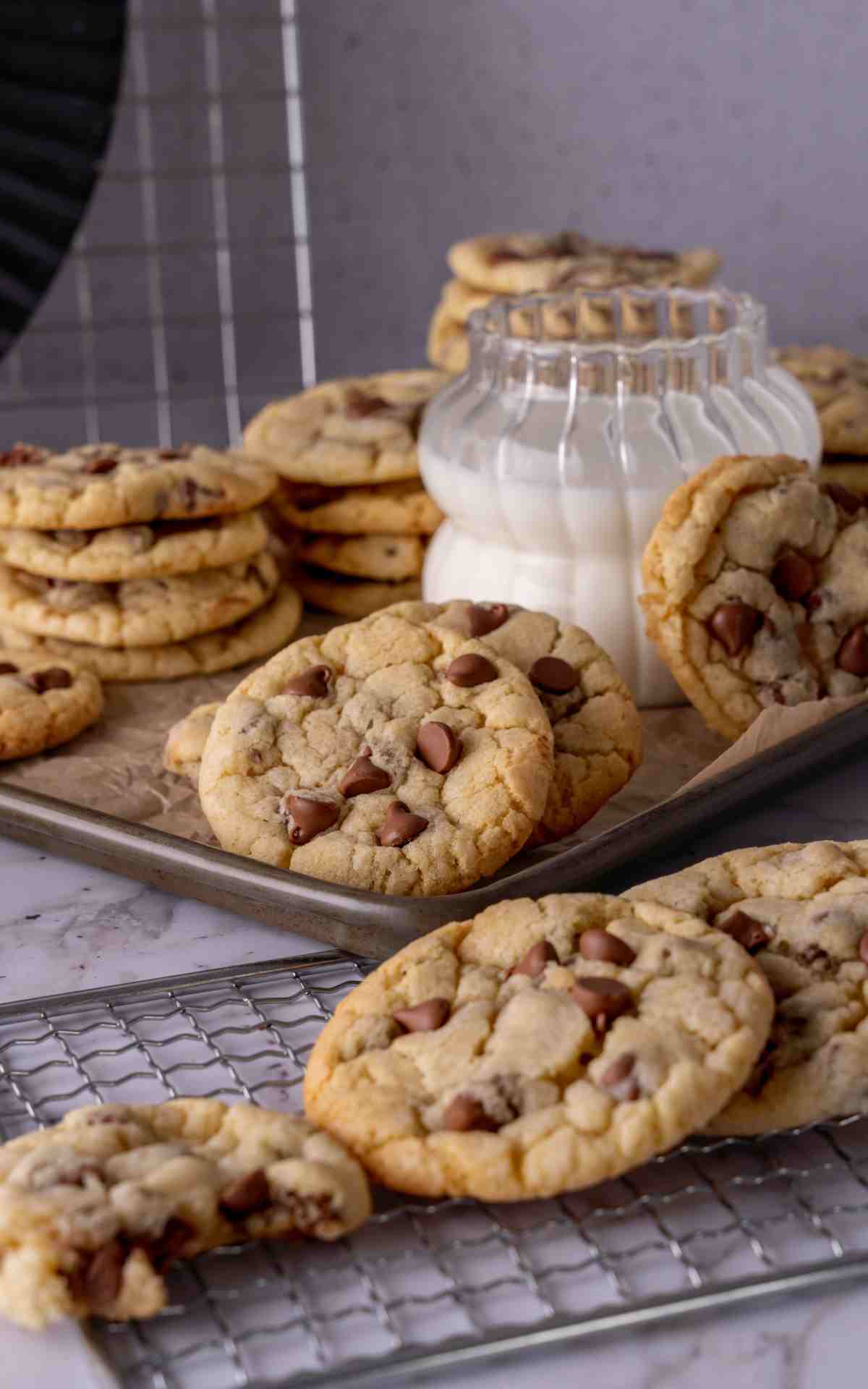 A glass of milk with soft chocolate chip sour cream cookies.