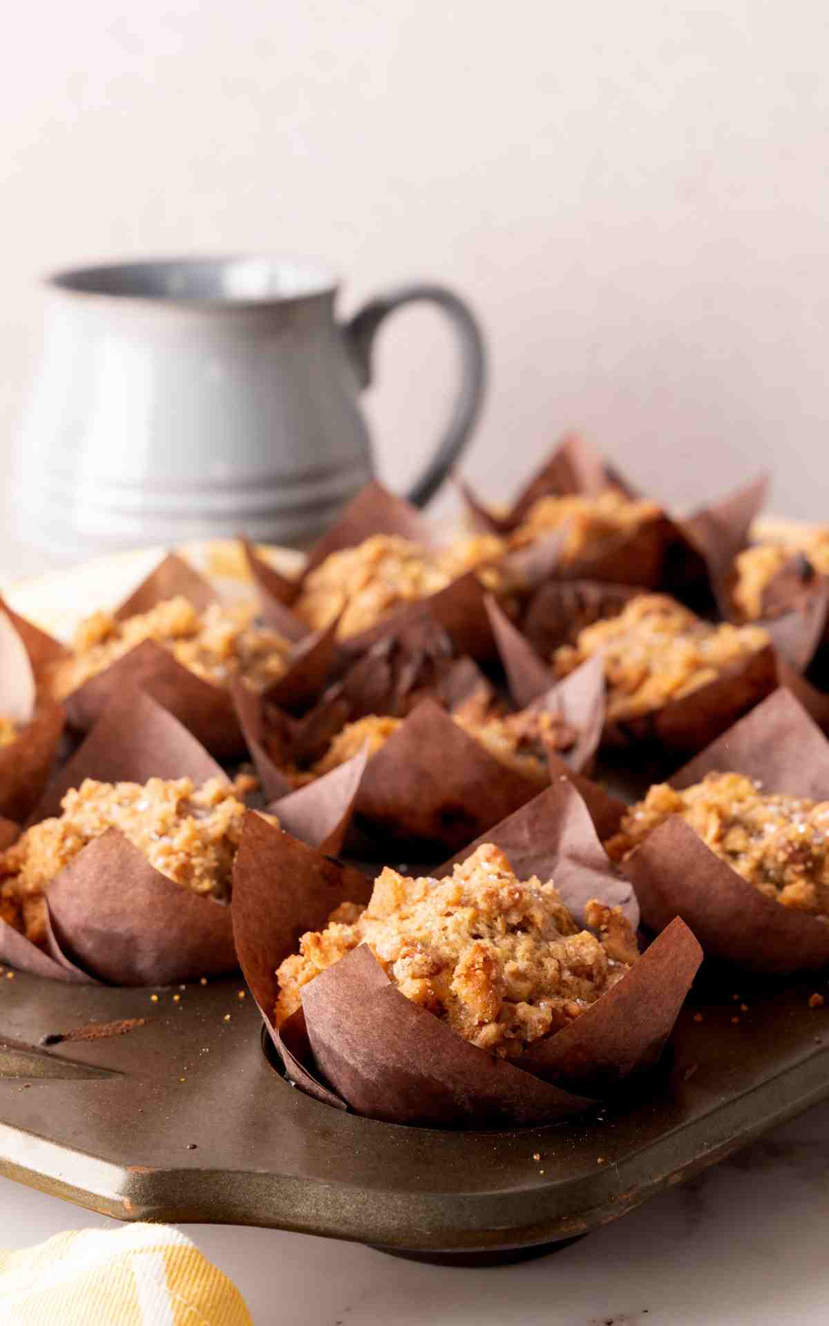 Banana walnut muffins with crunchy walnut topping in brown tulip wrappers.