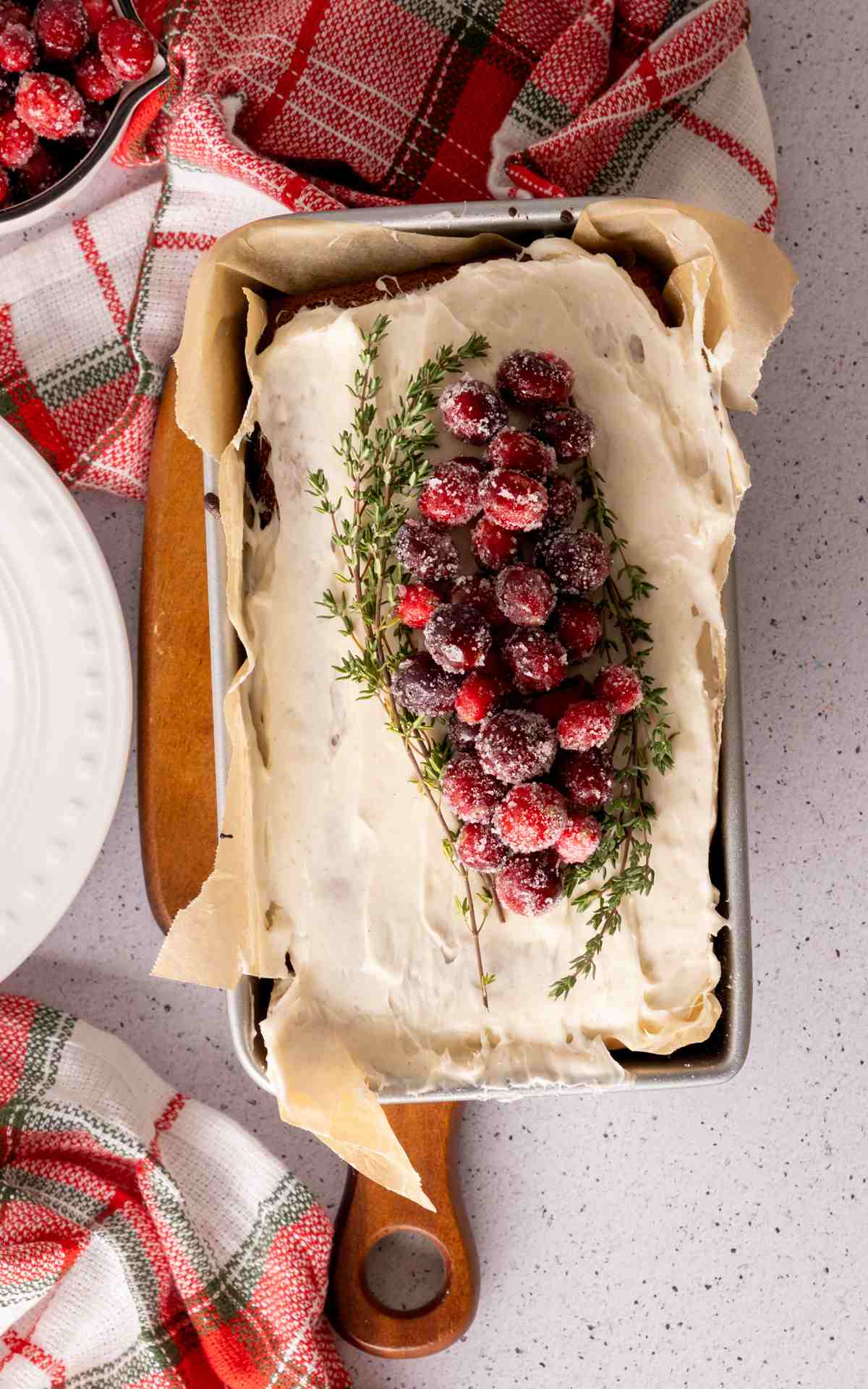 Cake Mix Gingerbread Loaf topped with cream cheese frosting and frosted cranberries.