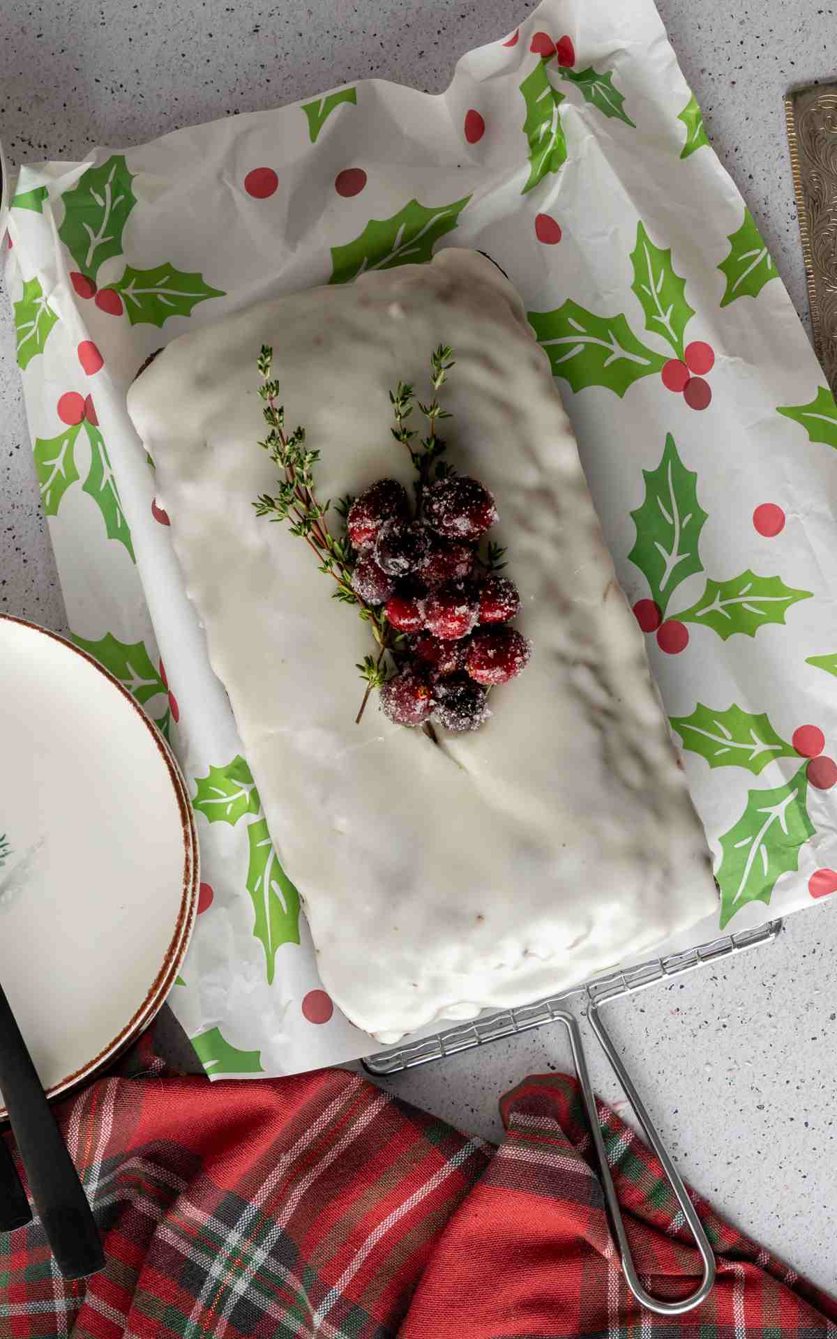 Overhead image of an iced and decorated gingerbread loaf cake with frosted cranberries.