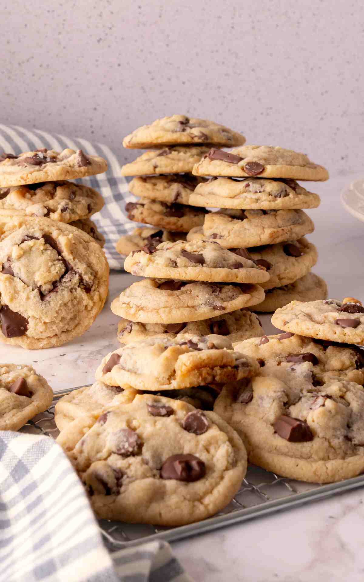 Stacks of eggless cookies made with chocolate chips and chopped chocolate bars.