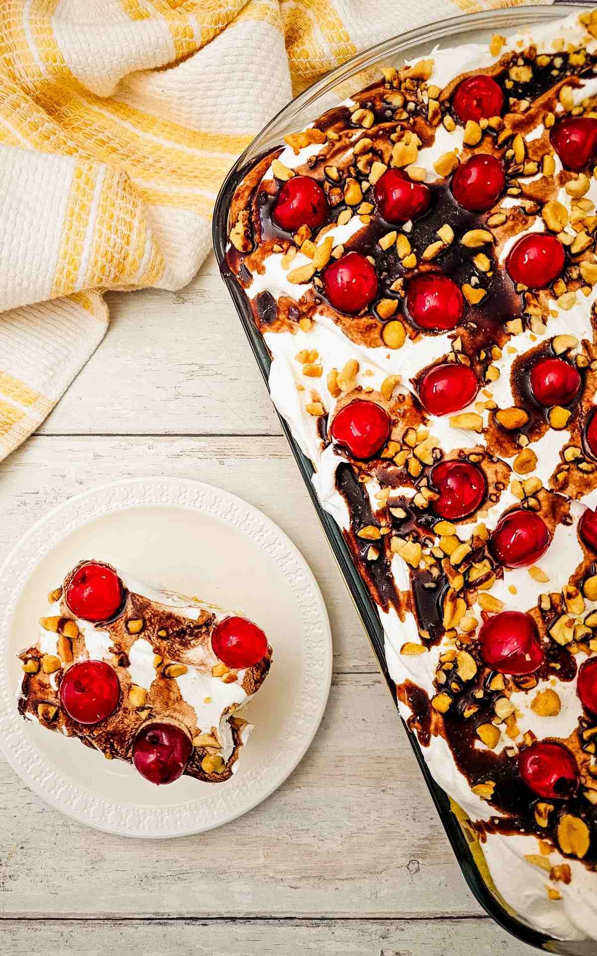 A 9 by 13 baking dish with banana split sheet cake a plate with a slice.
