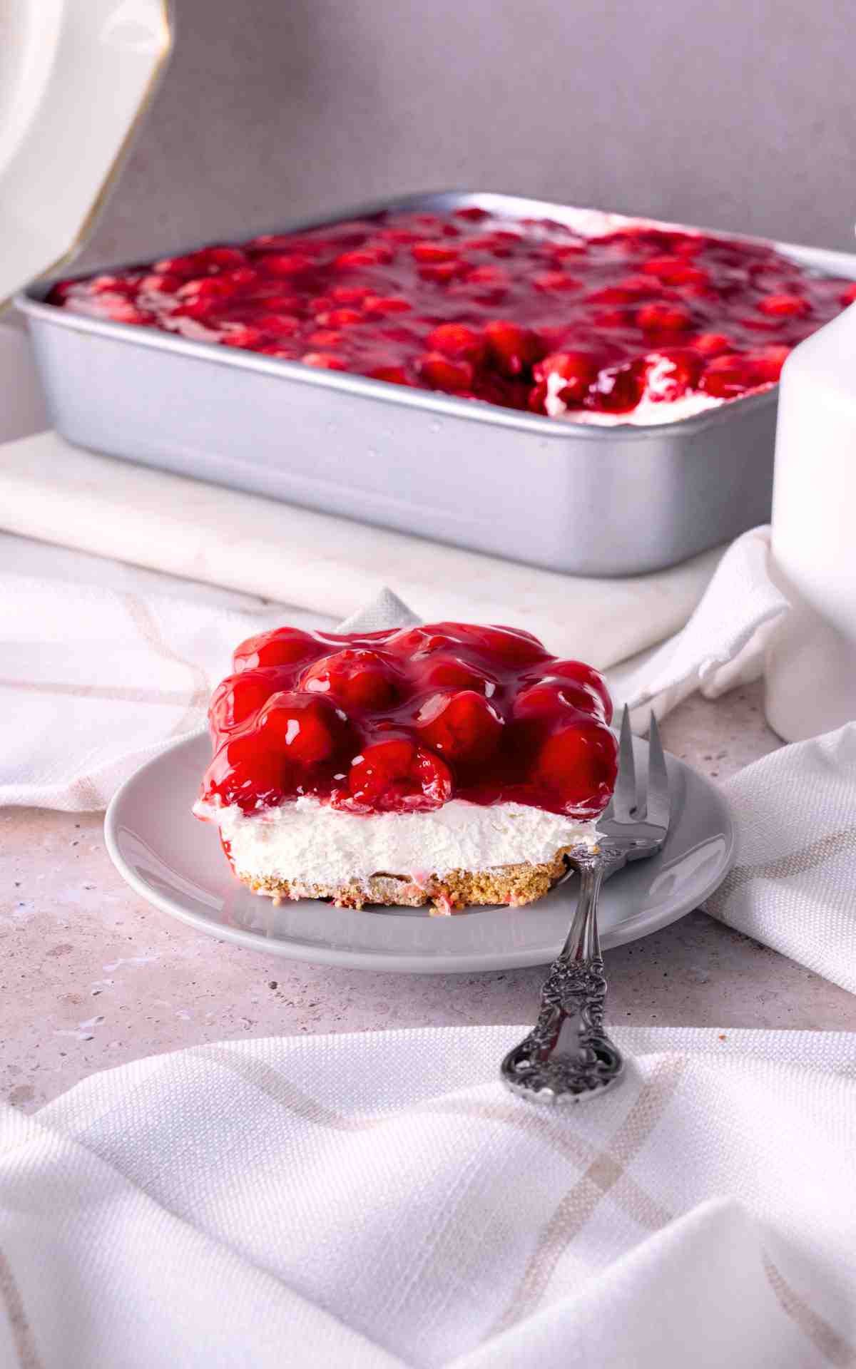 A slice of no bake cherry dessert on a plate.