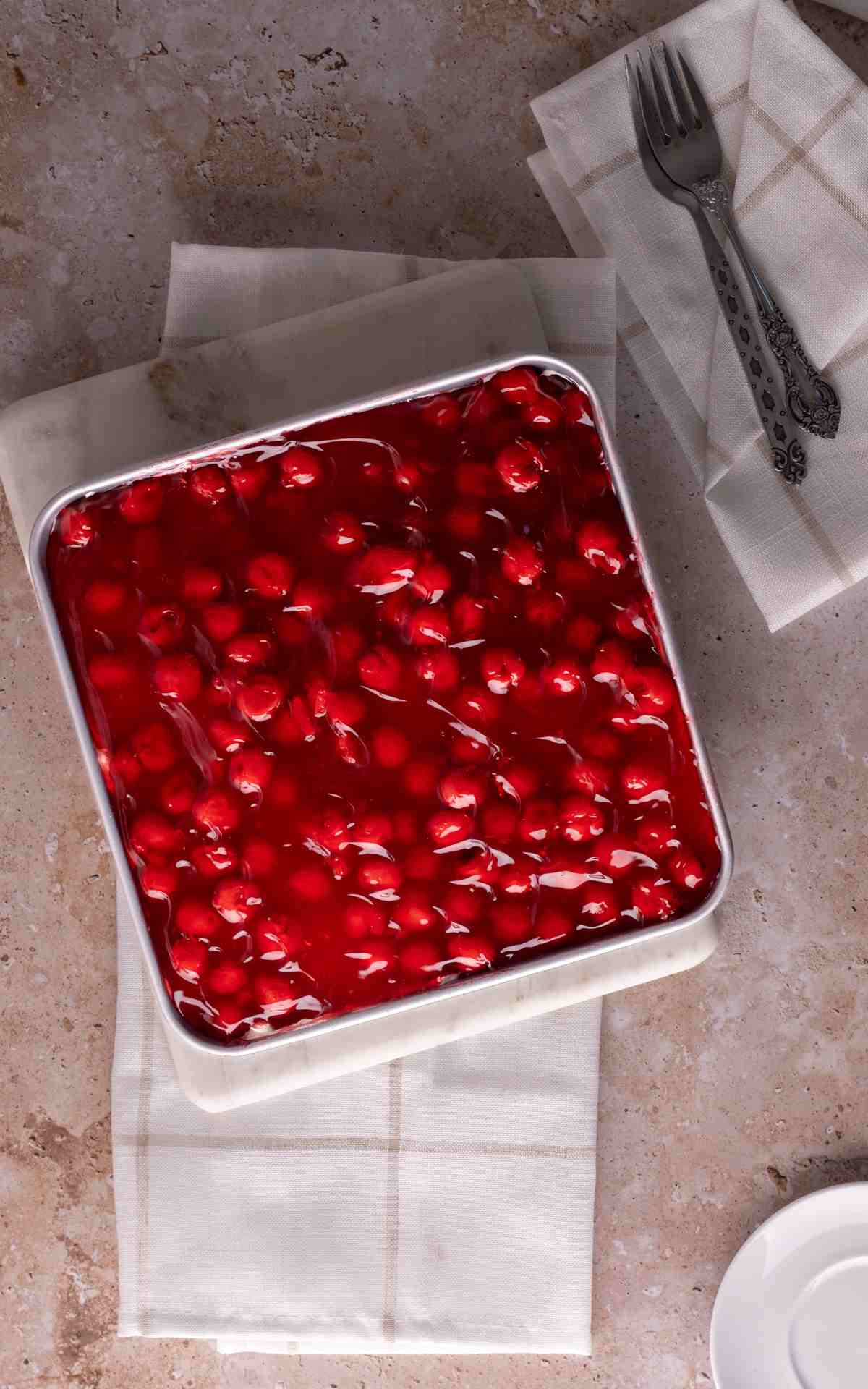 Cherry delight in a 9 by 9 pan with napkins.