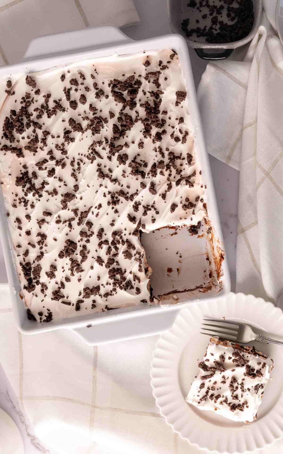 Overhead of a dish of a chocolate no bake dessert with a slice taken out of it.