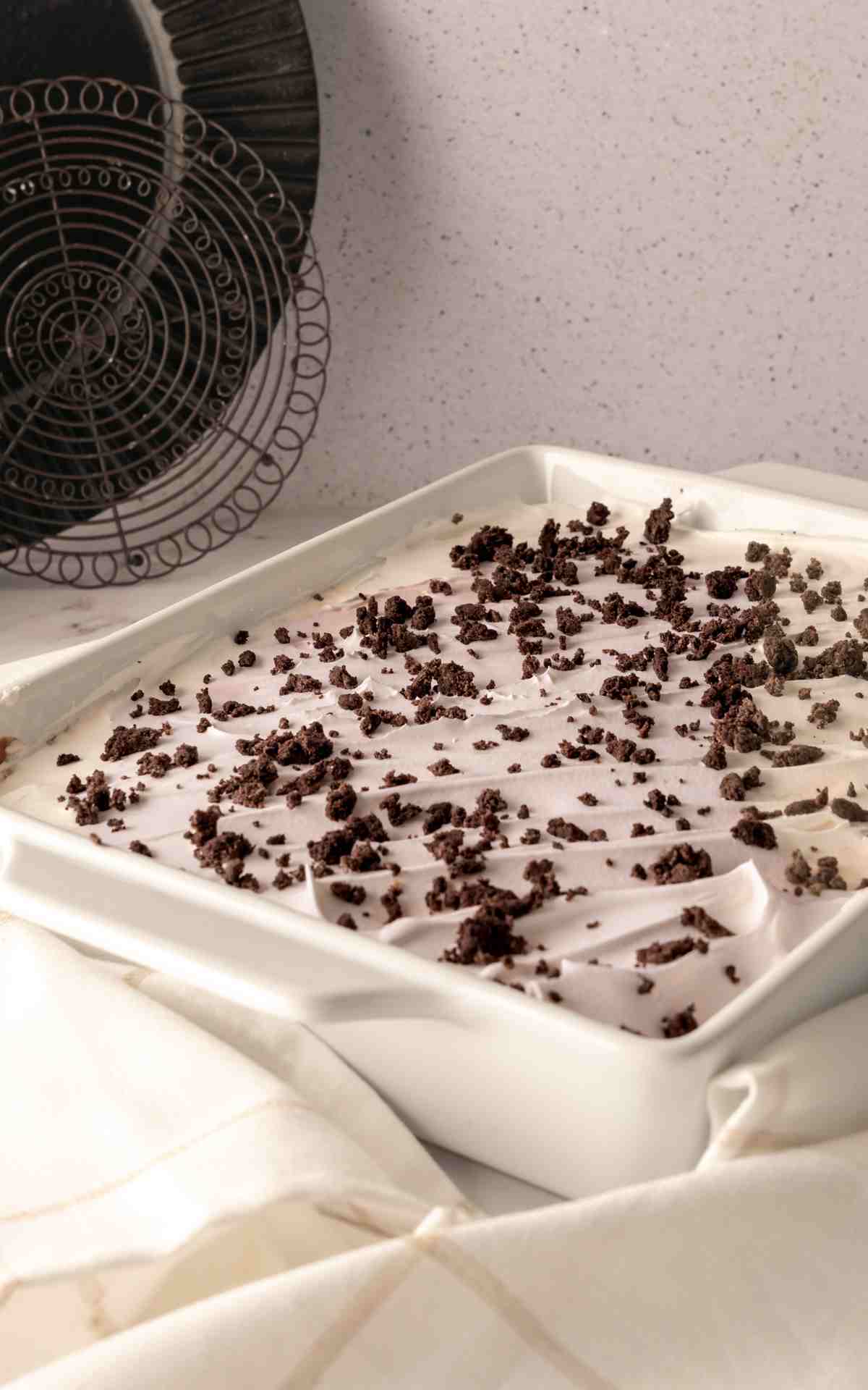 Side view of no bake chocolate delight in a ceramic dish.