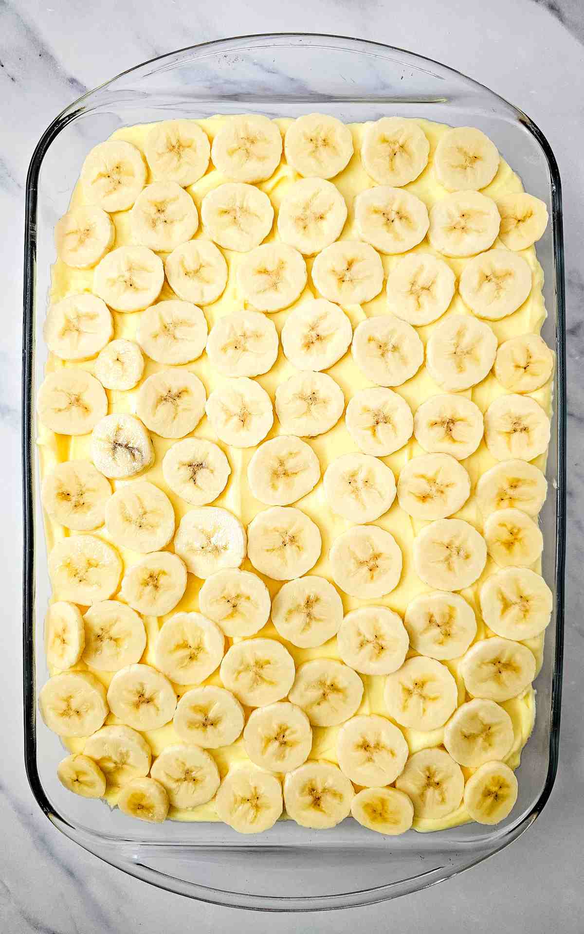 Sliced bananas on top of banana cheesecake mixture.