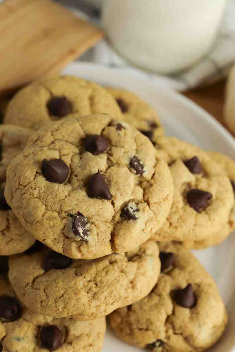 Pumpkin chocolate chip cookies stacked on a plate.