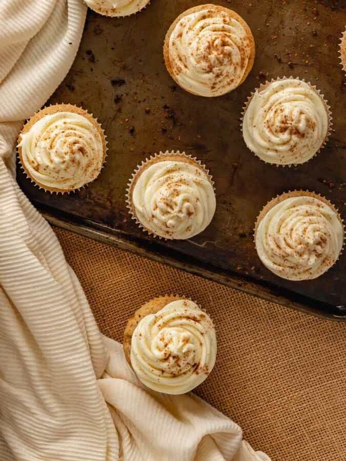 Cupcakes sitting on rustic baking sheet.