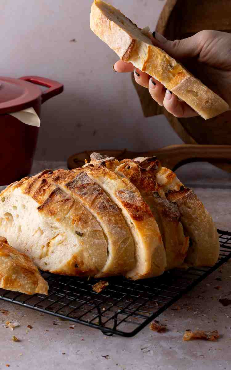 Jalapeno Cheddar Sourdough slices with a hand holding one up.