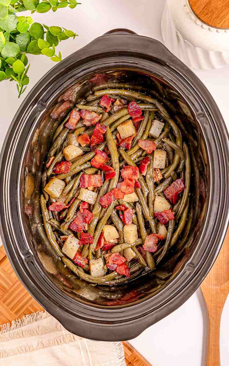 Top view of slow cooker green beans southern style with bacon and potatoes.