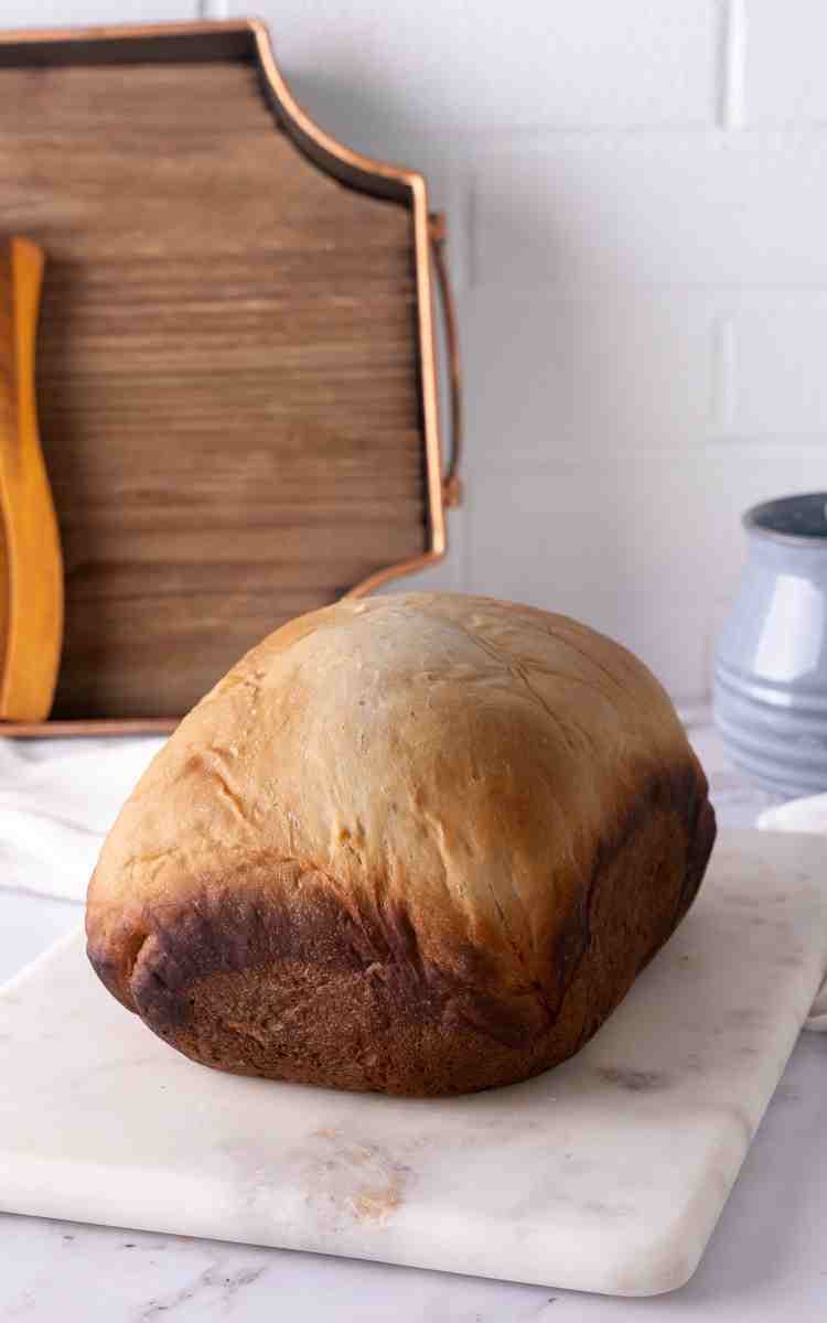 Unsliced white sandwich bread made in a bread machine.