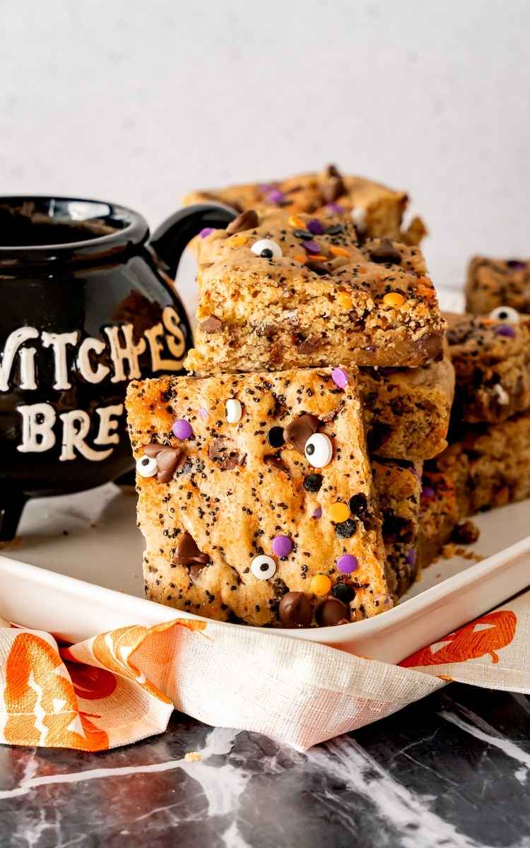 A cookie bar propped up on a stack of cookie bars with Halloween sprinkles.