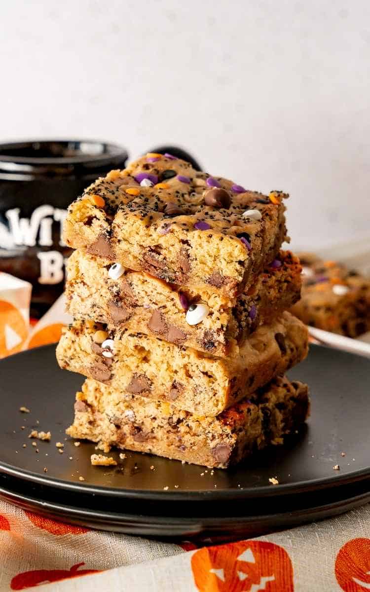Stacked cookie bars for Halloween on a black plate.