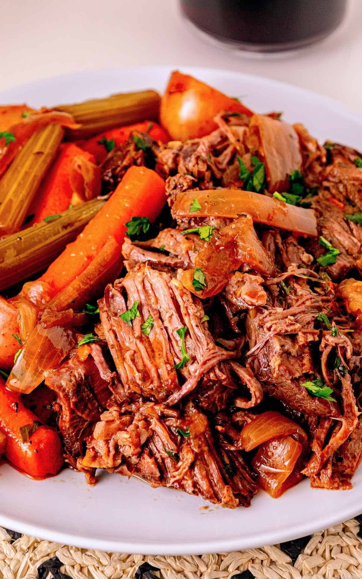 A plate of shredded pot roast and cooked carrots.